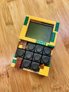 A handmade LEGO calculator with vibrant colors placed on a wooden surface, merging creativity and functionality.